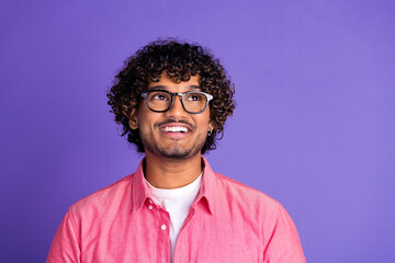 Obraz premium Photo of nice young man look empty space wear pink shirt isolated on violet color background