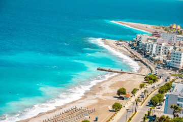 Obraz premium Aegean beach with sunshades in city of Rhodes (Rhodes, Greece)