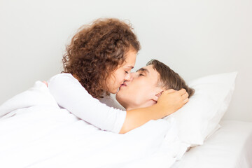 Love couple lying on white bed in morning happy and carring together