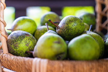 Close up view of green pears in a wicker basket.