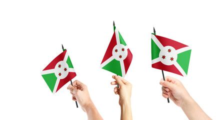 A group of people are holding small flags of Burundi in their hands.