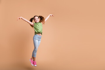 Photo of positive kid girl jump dance raise hands up feel graceful isolated pastel color background
