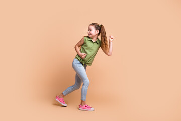 Photo of positive energetic kid girl run fast look profile side isolated pastel color background