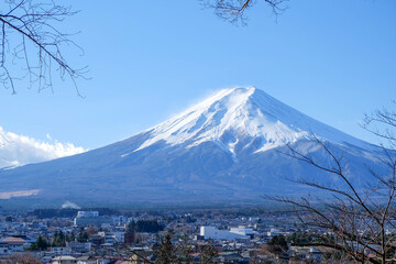 Fototapeta premium A distant view on Mt Fuji in Japan on a clear,The top parts of the volcano are covered with a layer of snow.