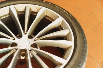 Car wheels, tires and wheels with a shiny disc in a car service center for seasonal replacement or after a breakdown.