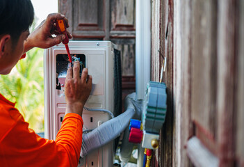 Air conditioning technicians install new compressor air Use a screwdriver to install the air conditioning system wiring and using monitor tool to check air conditioner system.