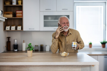 Caucasian man, communication and phone in kitchen while laughing, happy and talking to contact with...