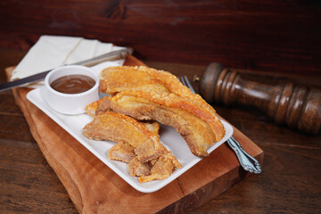 Thai food. Crispy fried pork belly cut into pieces on a wooden table.