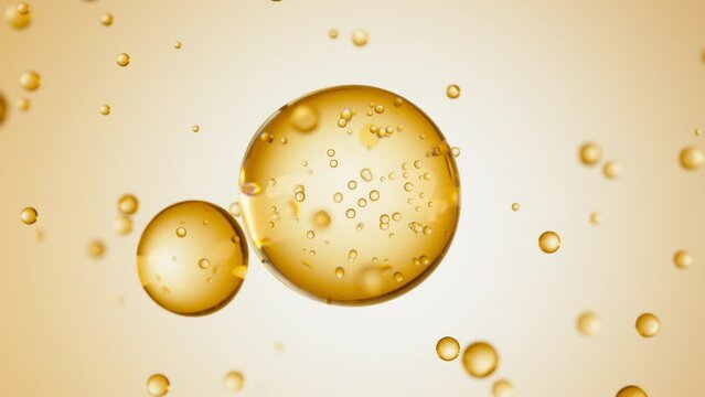 Macro of three drops of yellow liquid merge into one with bubbles inside. Skin care serum droplets uniting into one. Cosmetics moisturizer fluid concept