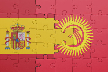 puzzle with the colourful national flag of kyrgyzstan and flag of spain.