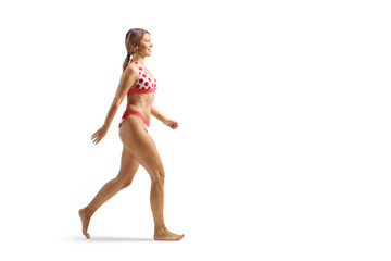 Full length profile shot of a young attractive woman in bikini walking