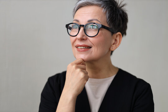 An elderly woman smiles cheerfully, radiating happiness and health, wearing stylish goggles