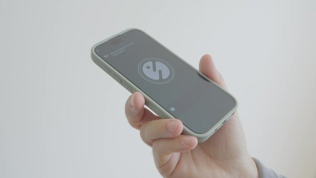 Person Using AI Chat Bot App on Smartphone. Asking chat bot for muffin recipe and taking notes. * Note - this a fake app.