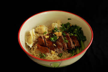 Chinese noodle topped with roasted duck with dumpling isolated