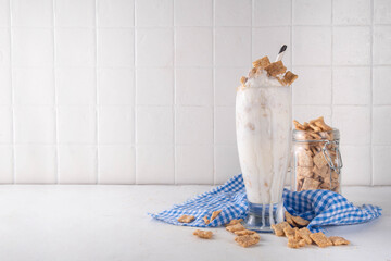 Cinnamon Toast Crunch cold milkshake drink with cinnamon sugar and caramel, glass of iced dairy...