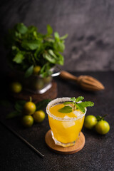 Fresh summer orange mojito with tangerine orange, mint and ice on black background