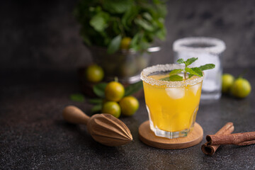 Fresh summer orange mojito with tangerine orange, mint and ice on black background