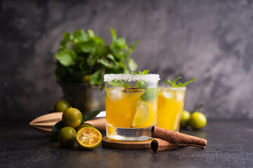 Fresh summer orange mojito with tangerine orange, mint and ice on black background