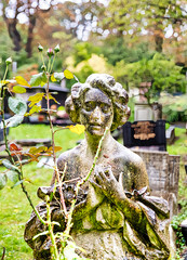 Frauenstatue hinter Rosen auf dem Highgate Cemetery Ostteil Camden, London	
