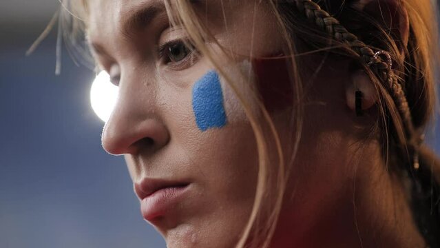 Shocked France fan. Close-up of face of sad, upset, sad woman who is in shock. French sports fan disoriented