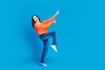 Full body photo of attractive senior woman dancing have fun dressed stylish orange clothes isolated on blue color background