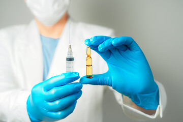 doctor or scientist holding ampules medicine vaccine and bottle for injection