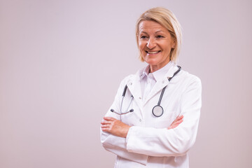 Portrait of mature female doctor on gray background.	