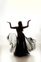 Fototapeta premium A mesmerizing young woman in a black dress gracefully dancing.