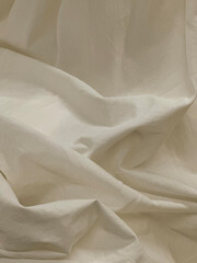 Drapery of white material with pleats.