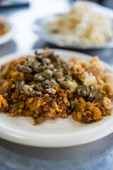 Phuket traditional food called O-tao, O Tao is a unique stir-fried dish made with Yam Oyster Omelettes mixed with battered taro, eggs, minced pork, garlic and spicy sauce