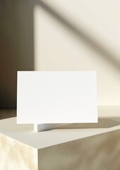 White blank card mockup on modern concrete table with shadow and sun light. Minimalist style. Isolated composition