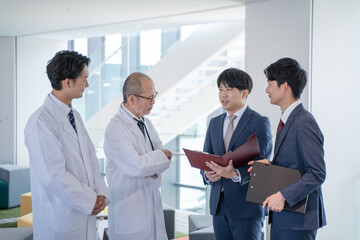 Fototapeta premium 病院で笑顔で会話する男性医師と医薬情報担当者MR