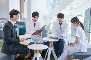 病院でミーティングする医師と看護師とビジネスマン