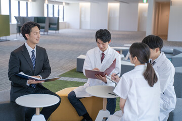 病院でミーティングする医師と看護師とビジネスマン