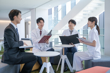 病院でミーティングする医師と看護師とビジネスマン