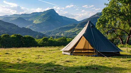 A black canvas tent stood on a large green lawn. Behind the tent, there is a backdrop of lush green mountains standing tall against the clear blue sky. The scene is quiet and beautiful.