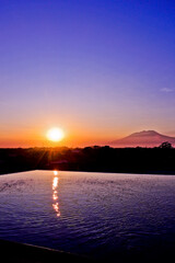 view of the pool with sunrise and mountain background