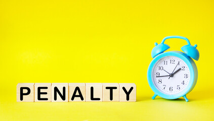 The word PENALTY made from building blocks on a yellow background with a clock