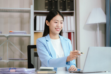 Happy young woman uses laptop computer for virtual meeting Have a video call at home Cheerful Asian woman communicating with colleagues and friends