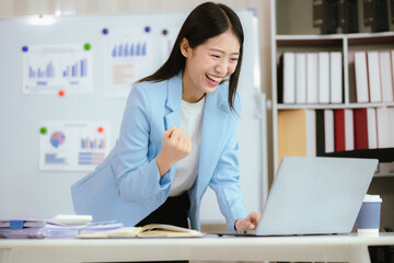 Happy young woman uses laptop computer for virtual meeting Have a video call at home Cheerful Asian...