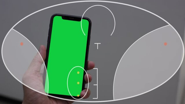 Hands are seen holding a phone in front of a green screen with progressive lens glasses. Phone green screen, Optical eyeglasses concept 