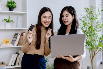 young woman looking at Laptop screen holding credit card, using Laptop secured online e-banking app, satisfied with online cashback purchase or good electronic banking services.