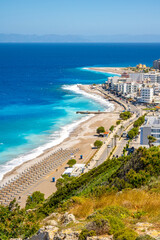 Aegean beach with sunshades in city of Rhodes (Rhodes, Greece)