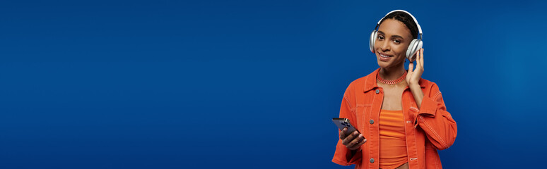 An African American man engrossed in conversation, holding a cell phone to his face.