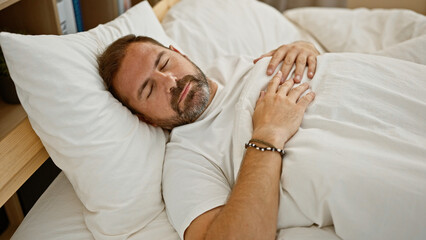 A middle-aged man with grey hair sleeps comfortably in a bright bedroom, evoking a sense of...