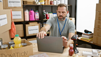 Hispanic mature man with grey hair managing donations indoor at a center, surrounded by supplies...