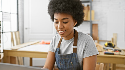 African american woman focusing on her carpentry project in a well-equipped workshop