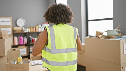 African american volunteer woman organizing donations in warehouse