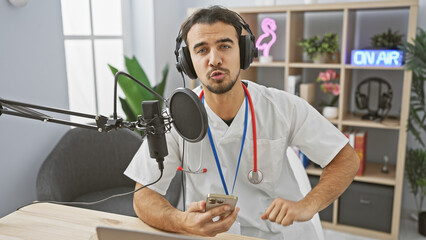 A young hispanic male doctor hosts a medical podcast from a studio, speaking into a microphone...