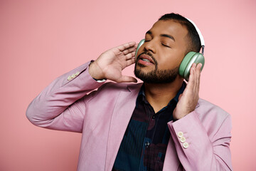 young African American man in braces listening to headphones in a stylish pink jacket.
